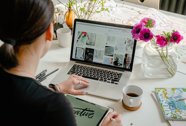 Woman working on a laptop at a desk.
