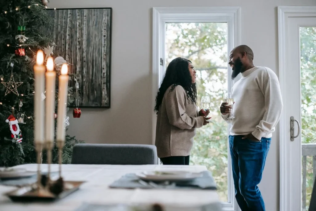 Couple drinking wine by Christmas tree