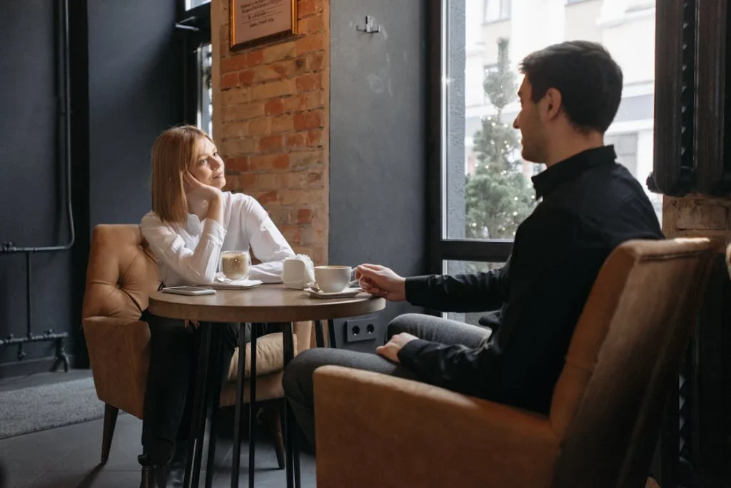 Two people chatting in a cozy cafe.