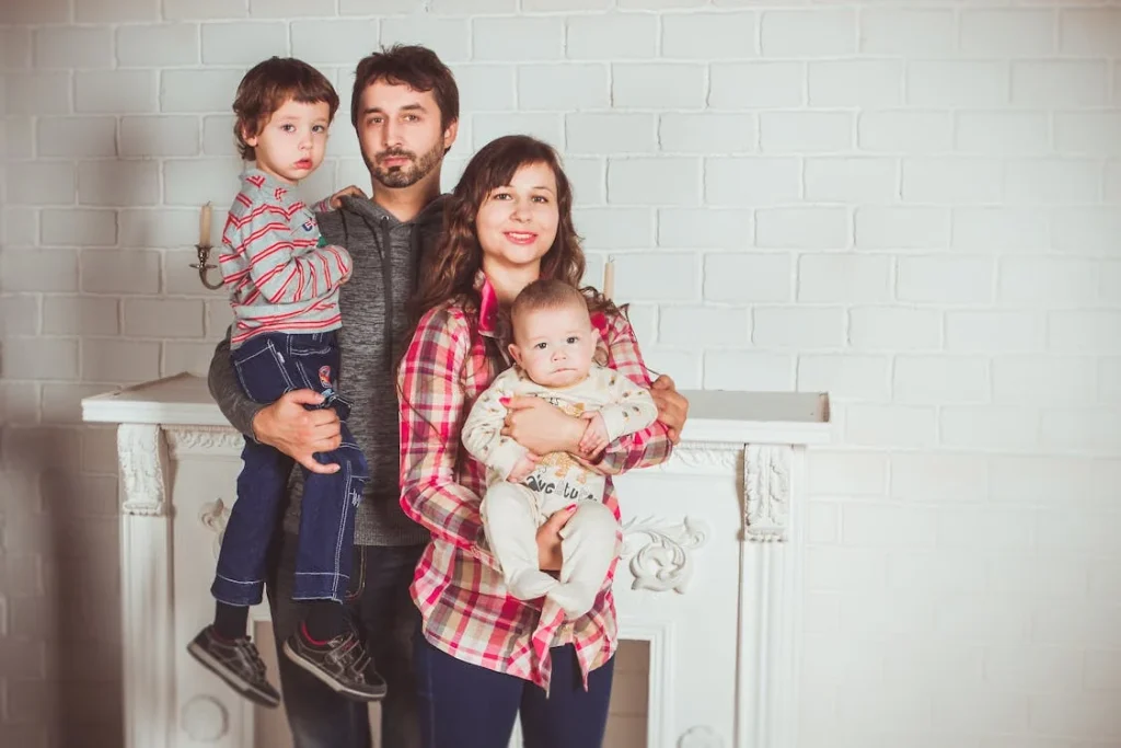 Family posing in front of white brick wall