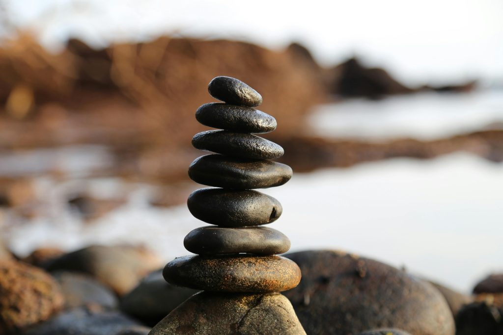 Balanced stones on rocky beach background.