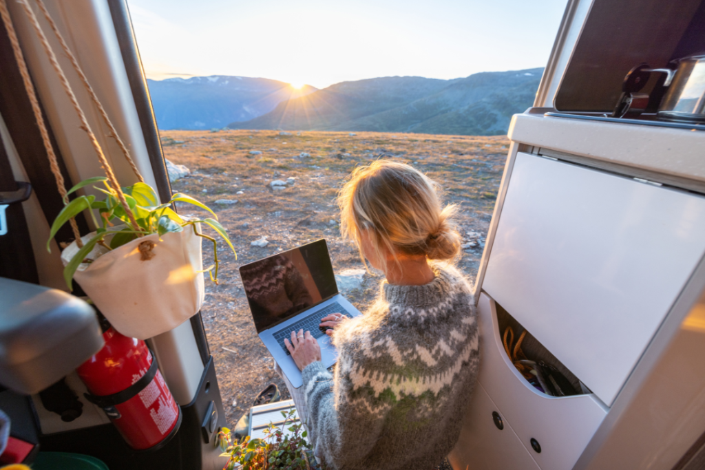 Woman working on laptop in camper van