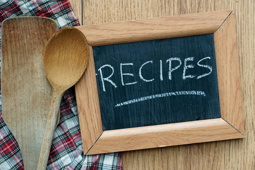 Wooden utensils and recipes chalkboard on plaid cloth