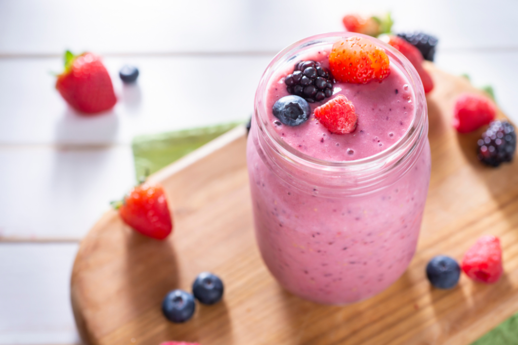 Berry smoothie in jar on wooden board