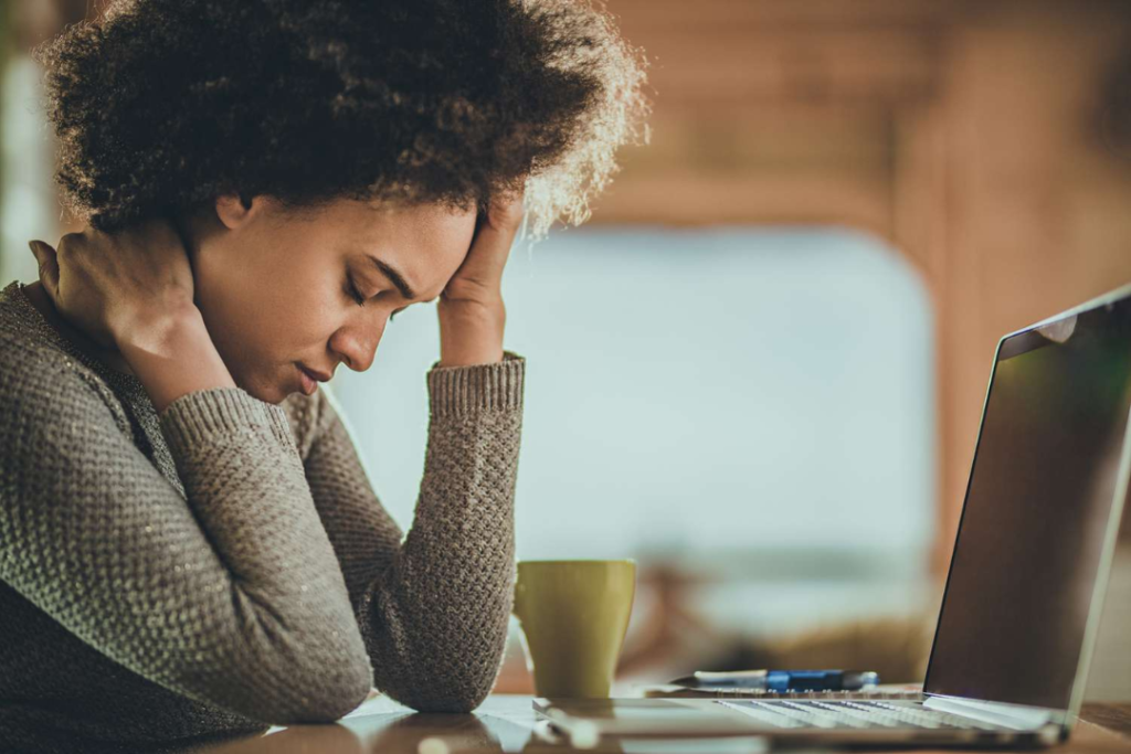 Stressed woman at desk with laptop